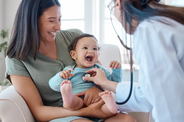medico a oscultar bebe ao colo